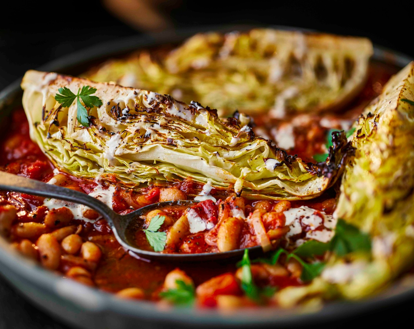 step 5 Nestle the cabbage wedges in the tomato sauce, then drizzle with the tahini. Finish with some fresh parsley (5 g).