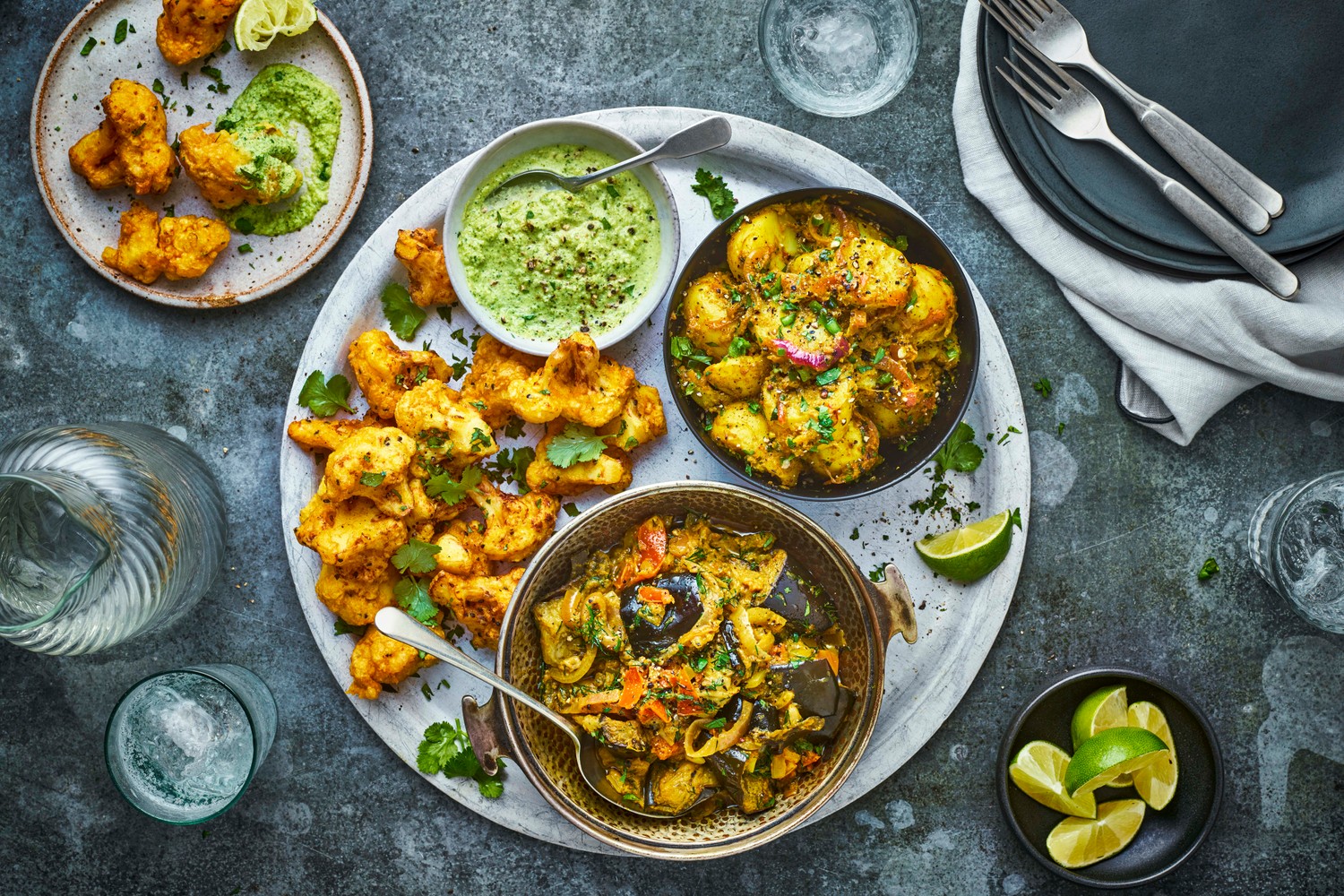 Baingan masala (aubergine curry) with aloo sabzi, cauliflower pakoras and mint and coriander chutney
