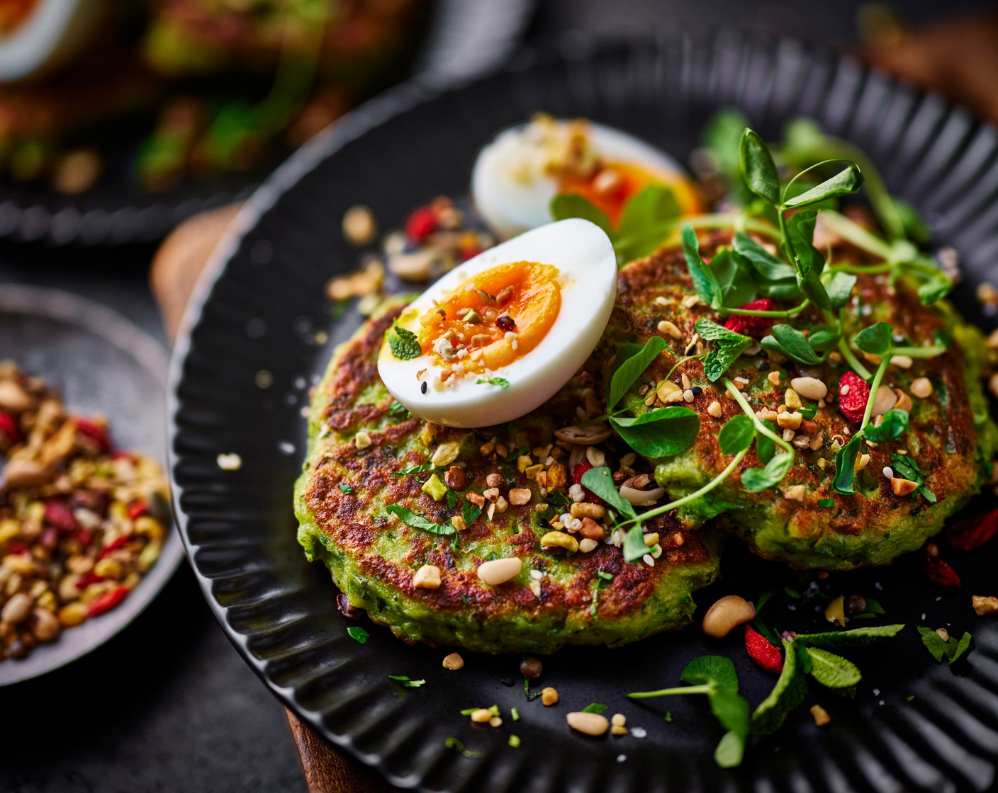step 6 Serve the pea fritters on plates topped with the soft-boiled eggs. Serve with more cottage cheese if you wish, alongside the pea shoots (20 g). Sprinkle over the gut booster mega mix (1 tbsp) followed by salt and pepper to taste.