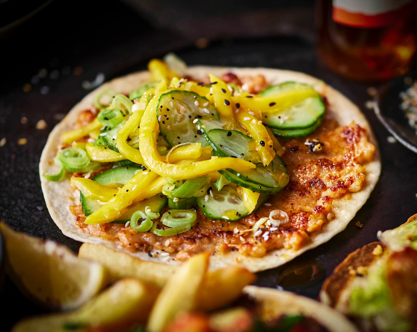 step 6 Assemble with the cucumber, mango and spring onion salad, then finish with chilli oil (to taste) and everything seasoning.