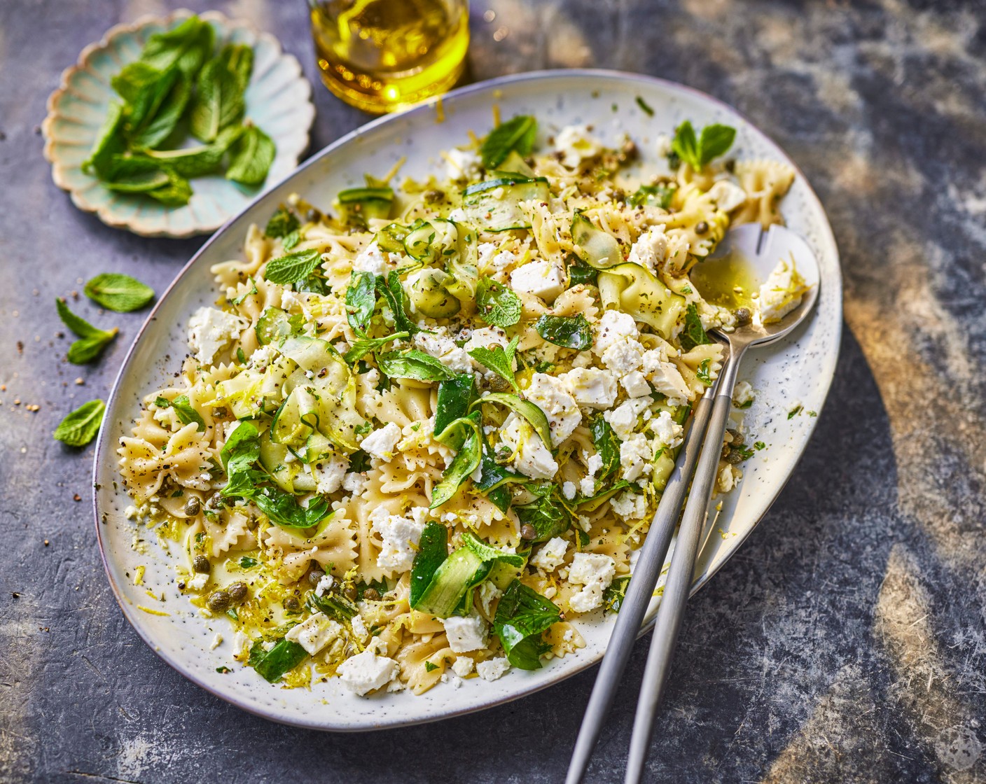 step 4 Stir the courgette into the pasta, followed by the dressing and feta (150 g). Add to a serving platter, top with the remaining lemon zest (1/2) and serve.