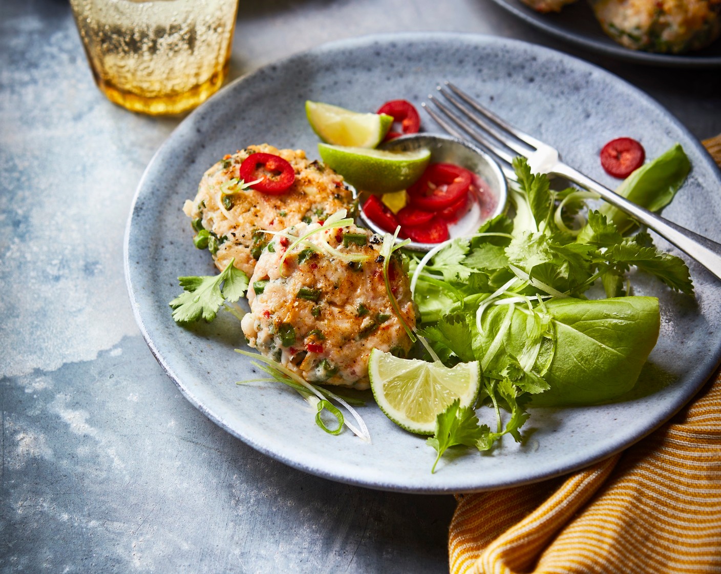 step 4 Divide the fishcakes between serving dishes. Scatter the spring onions (4) and remaining coriander leaves on top, and serve the lime wedges on the side for squeezing over. Serve with a fresh green salad, if you like.