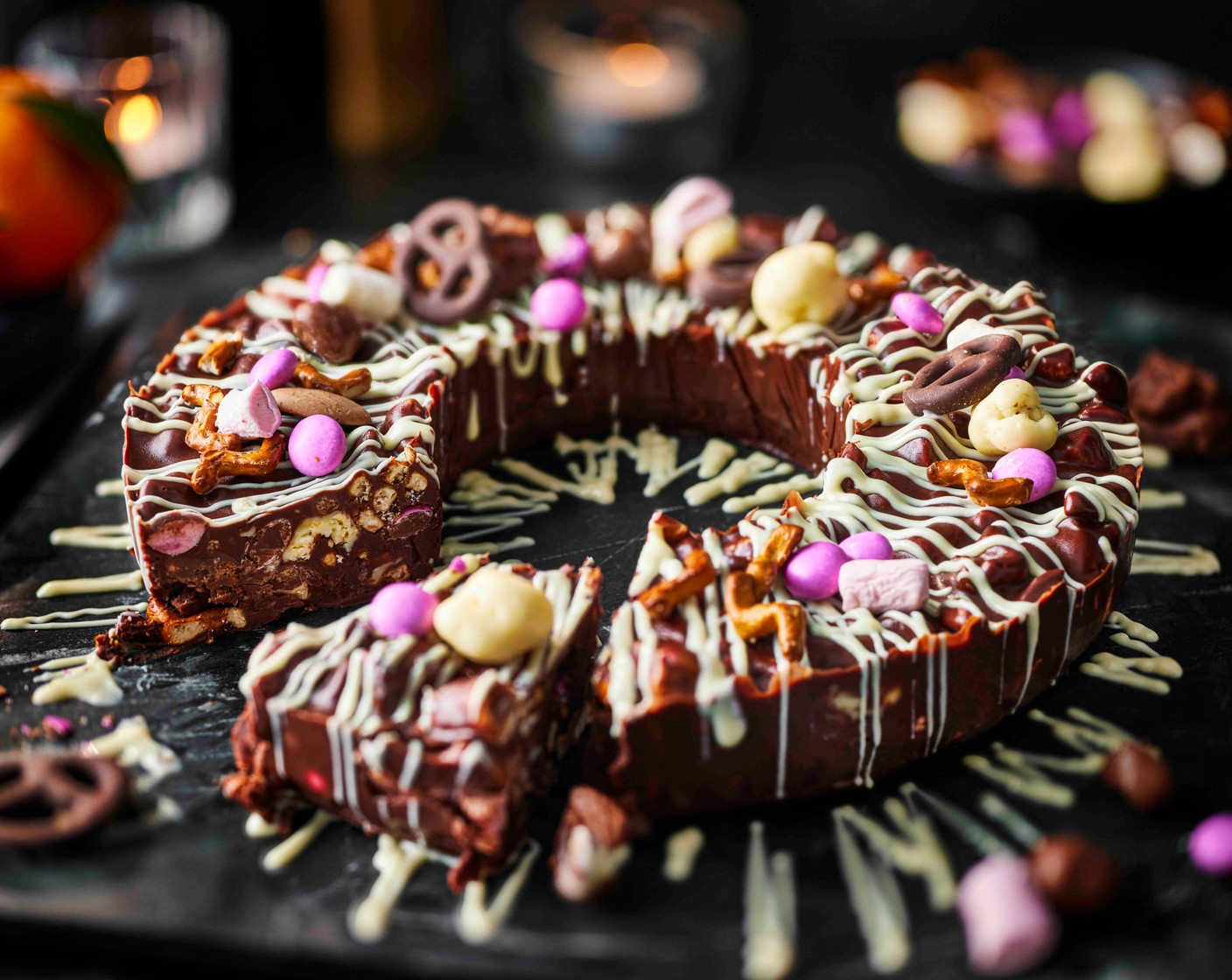 step 5 Carefully lift the wreath out of the tin. Use a knife to ease the ramekin out, and pop onto a serving plate. Drizzle the white chocolate over the wreath. Allow to set for a further 10 minutes, then serve in slices.