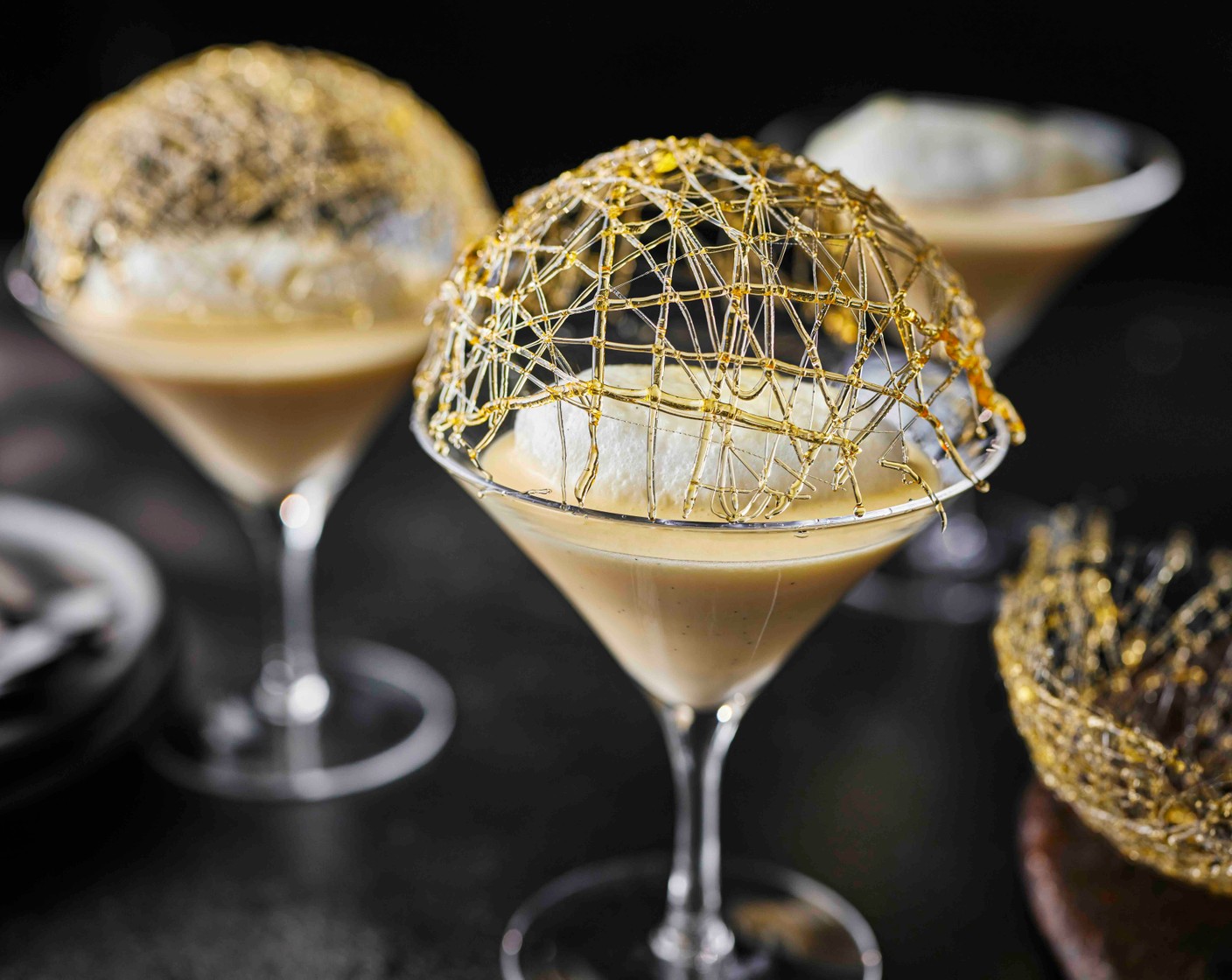 step 10 Divide the crème anglaise between three cocktail or dessert glasses. Carefully float a meringue on top of each, and finish with a caramel cage.