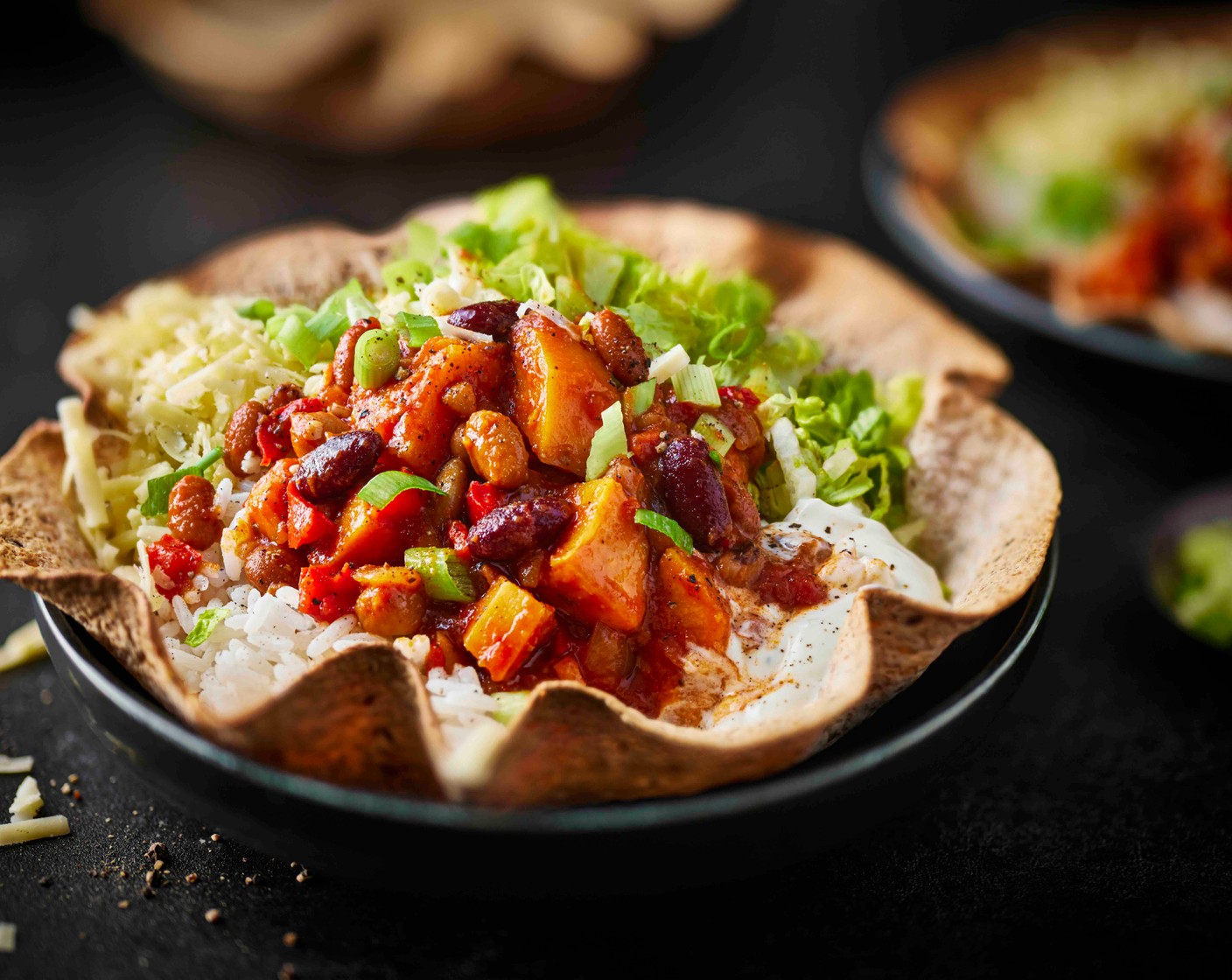 step 6 Serve the tortilla bowls with the rice, lettuce (2) and chilli. Top with spring onions (2), and the yogurt (as needed) and cheese (as needed), if using.