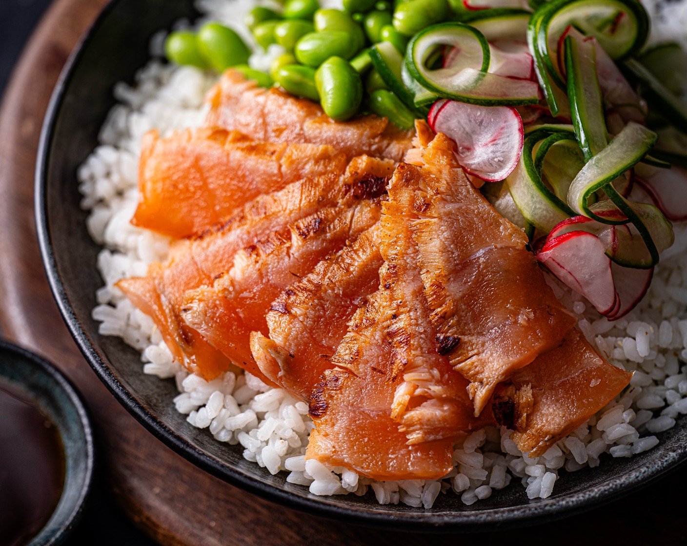 step 4 When you’re ready to serve, arrange the sushi rice in bowls and top with the pickled cucumber and radishes, the edamame beans and the salmon (1 pack). Serve with the ponzu sauce on the side.