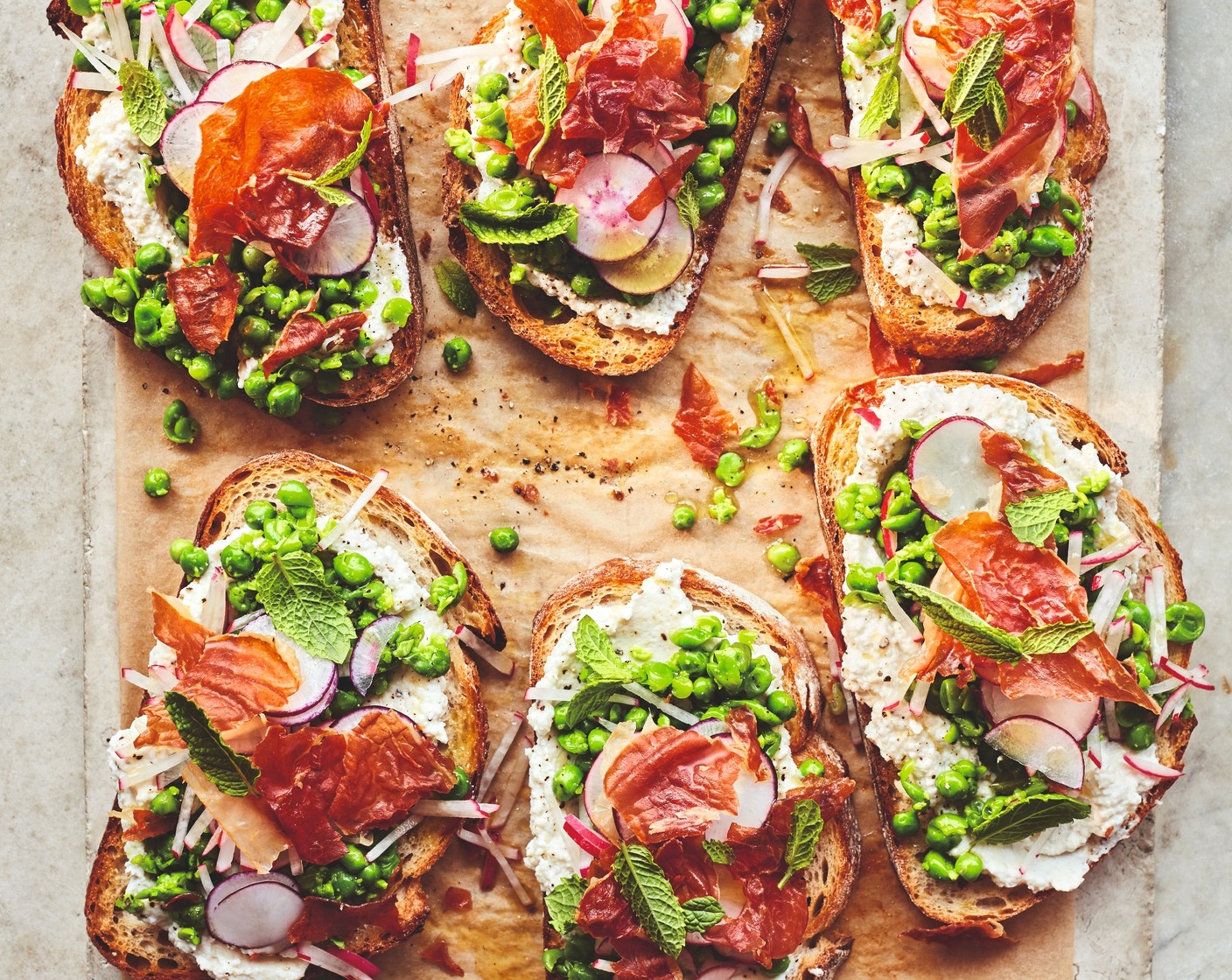 step 7 To assemble, pile the ricotta onto the sourdough halves followed by the peas, radishes and crispy prosciutto, if using. Finish with a little fresh mint (1 handful).