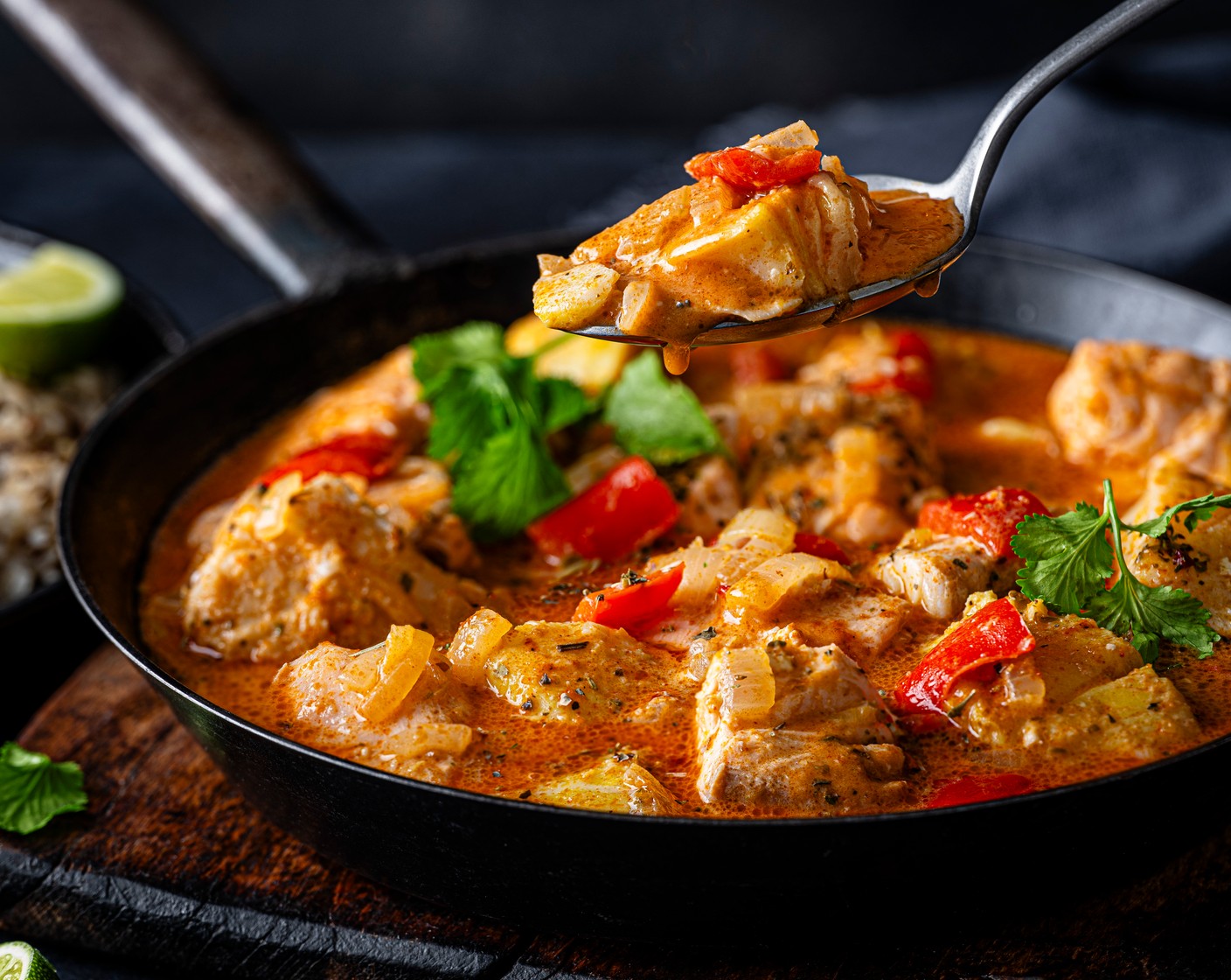 step 5 Spoon the rice into four bowls and top with the fish stew, then scatter with coriander (10 g). Serve with the remaining lime wedges (1).