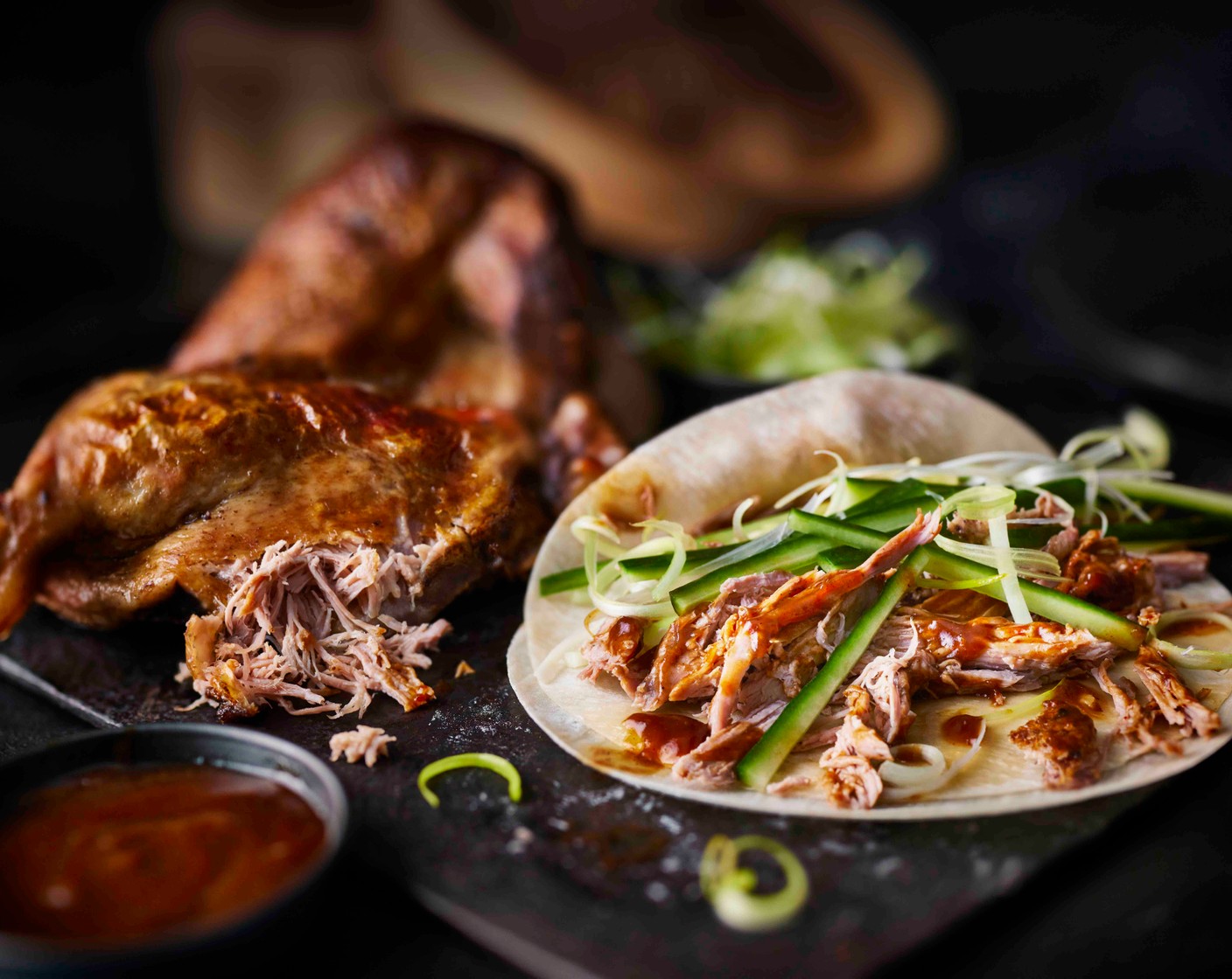 step 5 Spread the sauce sachet from the duck over the pancakes, then top with some of the crispy duck followed by the sliced cucumber (1) and spring onions to serve.