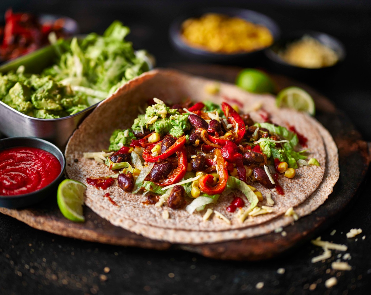 step 5 Set out the warm beans, avocado, sweetcorn, wraps (4), grated cheddar (100 g) and lettuce (1 head). Let everyone build their own wraps.