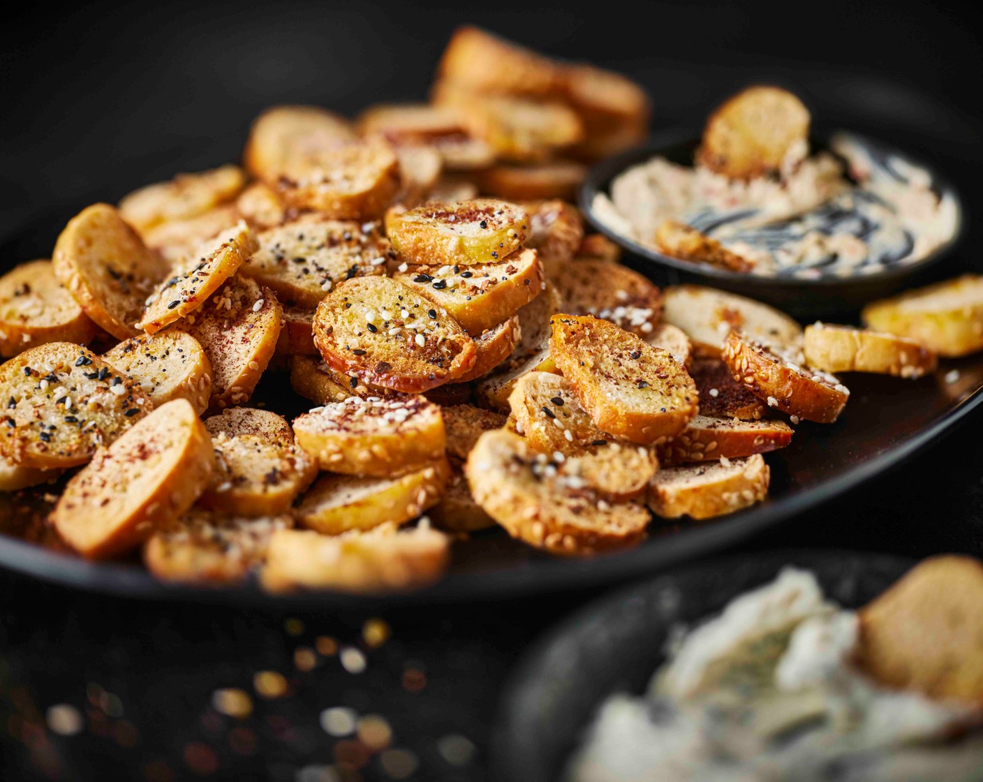 step 4 Once cooled, serve the everything bagel chips with the New York deli style cream cheese spread (as needed) and the sumac sesame bagel chips with the dill and chive cream cheese spread (as needed).