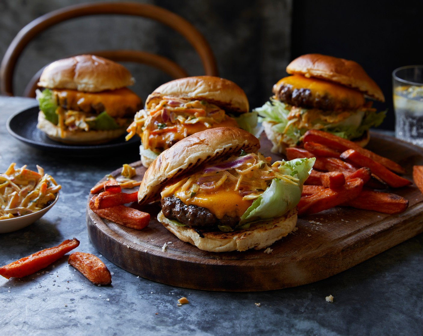 step 7 Finally, build your ultimate burgers by adding a handful of crunchy iceberg (1) onto the base of the bun and then adding the cheese-topped burgers. Finish with a spoonful of the slaw (300 g), top with the other half of the bun, and serve with a generous portion of sweet potato wedges.