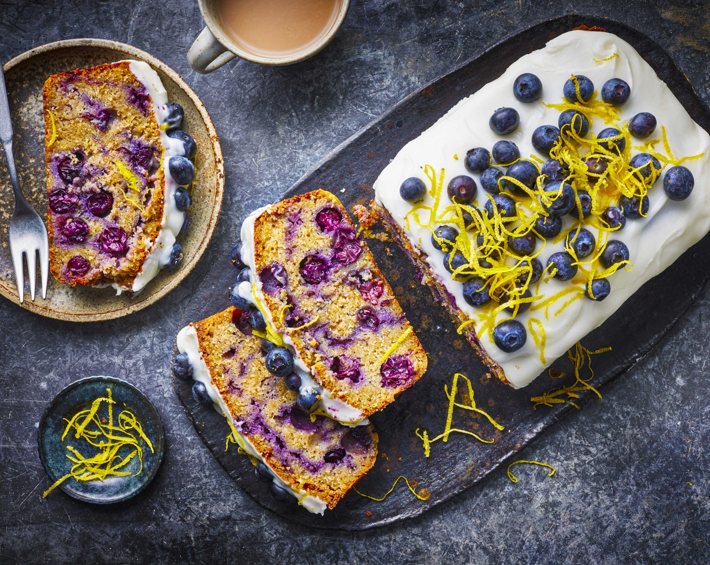 step 7 Once the cake has cooled completely, whisk together the icing sugar (200 g) and lemon curd yogurt (3 tbsp) until smooth then spread over the cake. Decorate with blueberries (100 g) and lemon zest (1) and slice thickly to serve.