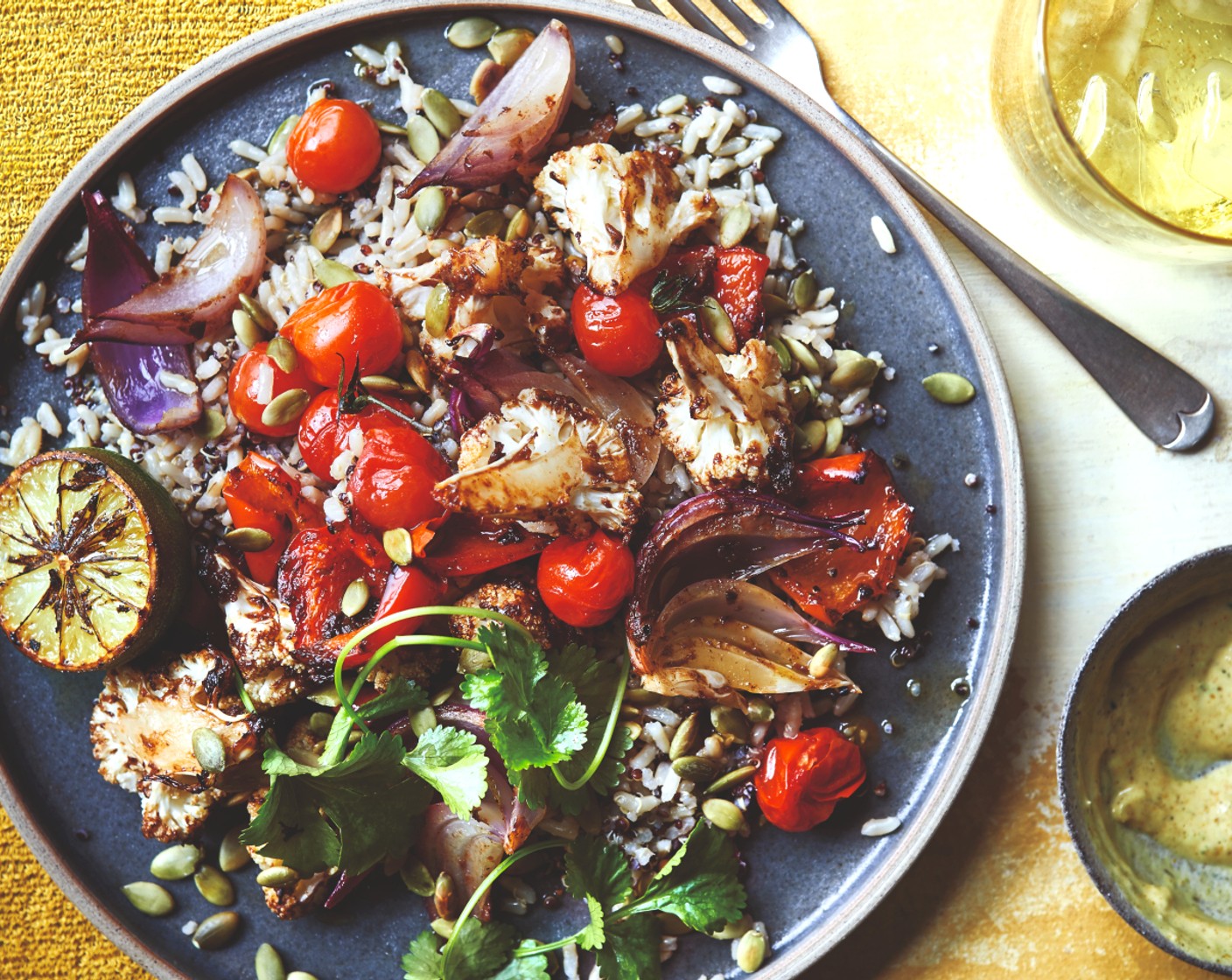step 5 Serve the roasted veg with the rice and quinoa, charred limes, satay (2 tbsp), fresh coriander (1 handful) and pumpkin seeds (1 handful).